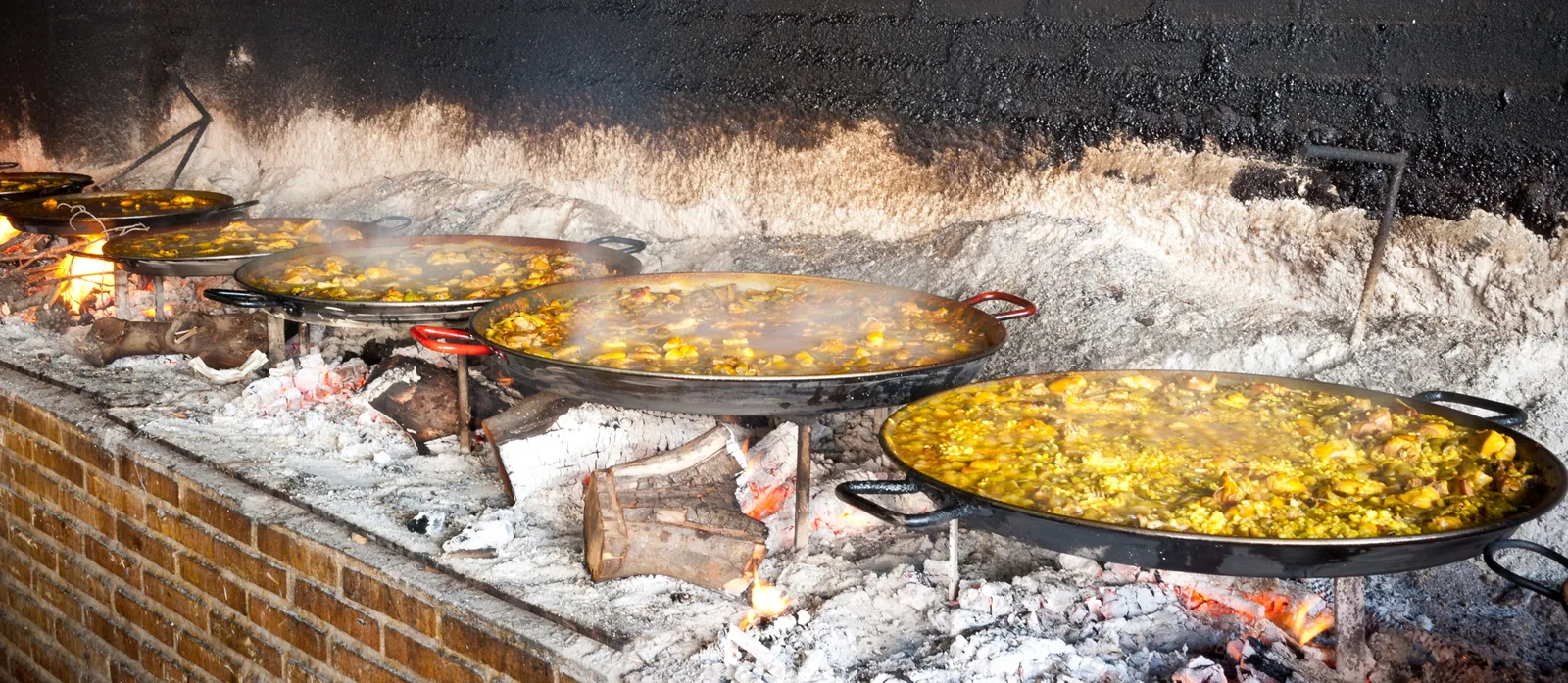 Foc de Mercat — a paella pan over the orange-wood fire