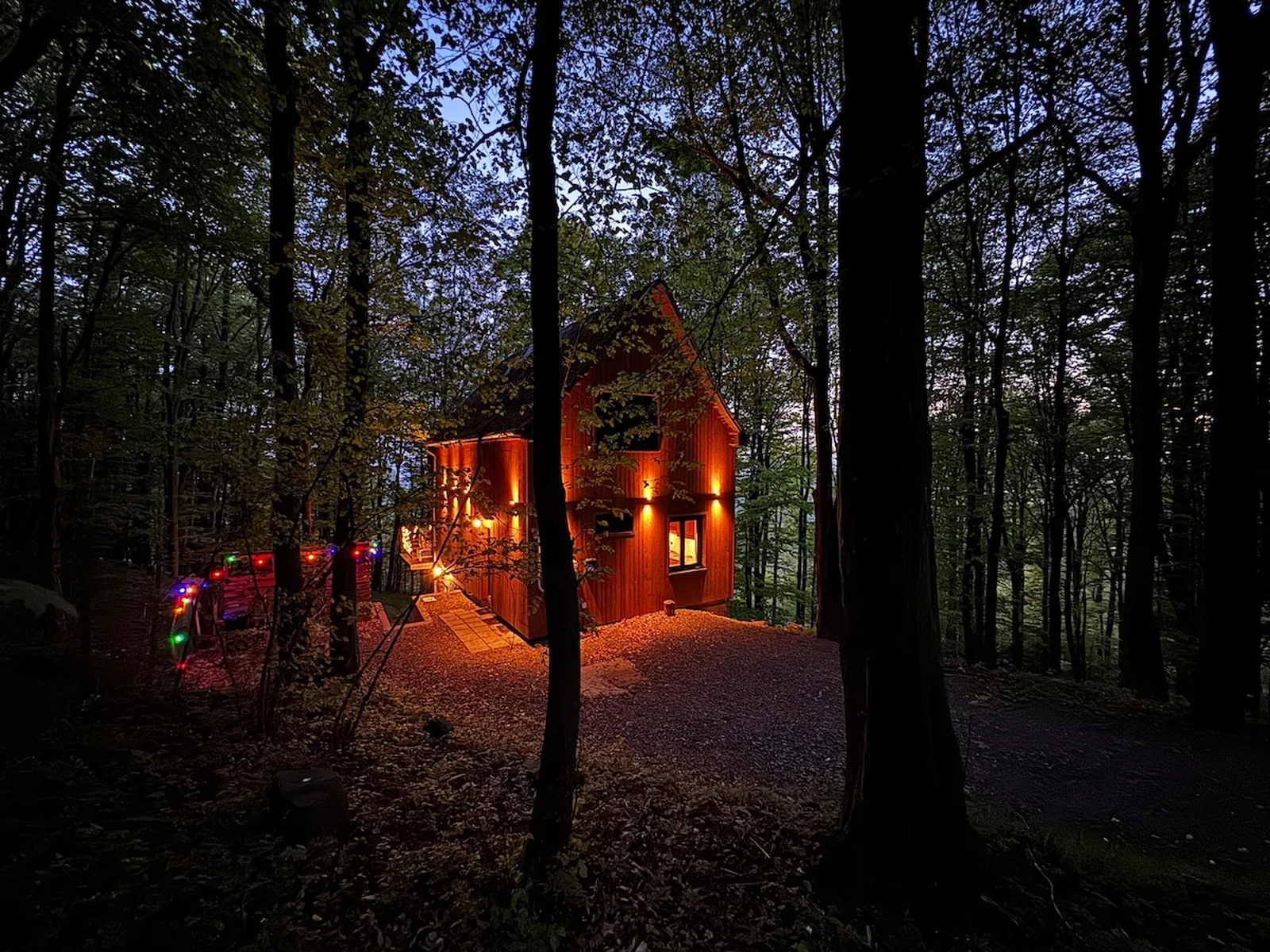 The warm-lit wooden hillside cabin where groups gather before stepping out under the stars